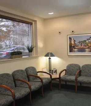 The waiting room, with chairs along a wide window onto the street.